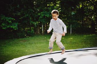 Smiling young boy jumping on trampoline