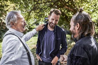 Three happy men talking in garden