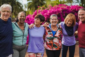 Group of happy senior people having fun after yoga lesson at city park